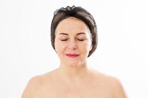 Botox injection beautiful middle-aged woman in a medical cap with closed eyes before surgery isolated close up photo