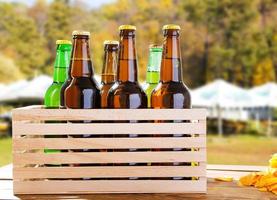 craft beer in wooden box on blurred background of summer pub area photo