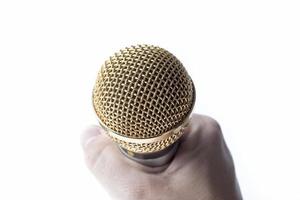 A man's hand holds a microphone on a white background. photo