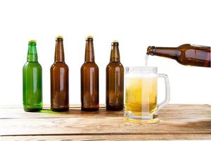 Glass and bottle of beer with no logos on wooden table isolated copy space, bottle mock up. Beer bottle studio shot with cap isolated. photo
