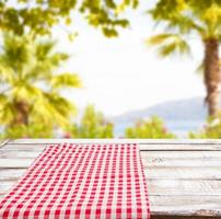 empty food table,red tableclothes on blurred summer park background, copy space photo