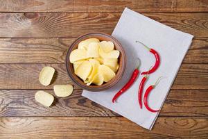 top view potato chips and red chili peper on wooden table,tablecloth photo