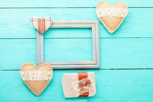 Romantic frame with copy space and accessories on blue wooden background. Top view photo