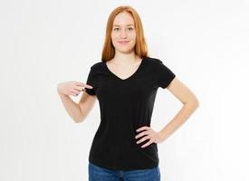 t-shirt design, happy people concept - smiling red hair woman in blank black t-shirt pointing her fingers at herself, red head girl tshirt mock up photo