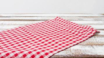 checkered tablecloth on wooden table on grey background photo