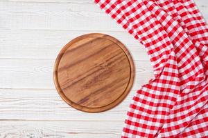 Top view wrinkled red tablecloth and plank on wooden table, mock up photo