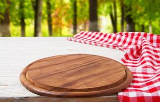 empty board and crumpled tablecloth on table against a blurred background of the park photo