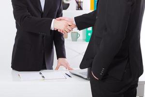 Business deal. Partnership meeting concept with successful businessmen handshaking at office background. Selective focus, copy space and horizontal. Team work and trust photo