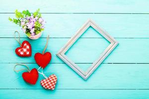 Valentines accessories and vase with flowers on blue wooden table. Top view photo