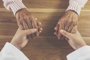 The doctor shook the patient's hand as a sign of encouragement. photo