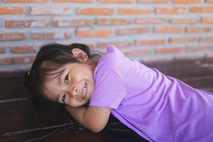 Cute little girl wearing purple clothes is smiling happy. photo