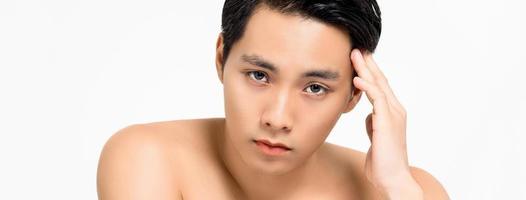 Shirtless young handsome Asian man with hand touching head isolated on white banner background for skin care and beauty concepts