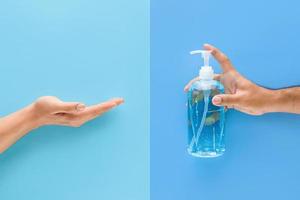 Man hand pumping alcohol gel to another hand for cleaning and protecting from germs and virus photo