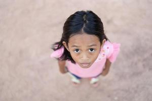 un retrato de una niña asiática de pie en el suelo. foto