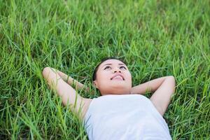 Beautiful Young Woman,Healthy Smiling woman Relaxing in Green Grass at meadows. photo