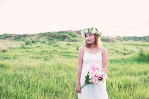 young beautiful woman holding flower on her hands and smiley. photo