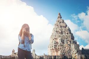 joven y atractiva mujer fotógrafa turista con mochila que viene a tomar fotos en el antiguo templo de peldaño fantasma en tailandia.