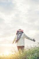 Young girl spreading hands and joy with nature while winter time at sunset background. photo