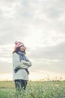 joven mujer hermosa con ropa de invierno mientras está de pie disfruta con la naturaleza. concepto de horario de invierno. foto