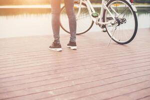 Woman feet standing near bike on the wooden bridge,Relaxing freedom,ready to go riding. photo