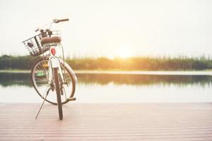 tono vintage de bicicleta con cesta en muelle vacío, día de verano. foto
