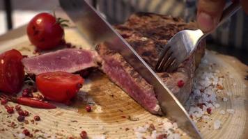 bistecca tagliata del cuoco del primo piano con carne appena grigliata di sangue
