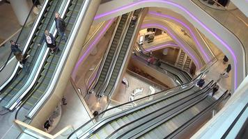 Gallery of escalators in shopping center - people go up and down