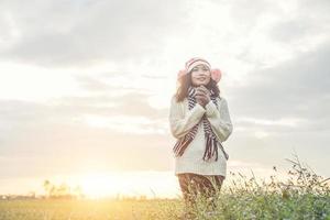 Young beautiful woman wearing winter clothing while standing enjoy with nature. Winter time concept. photo