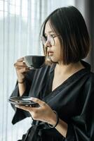 Women wearing black robes, handing coffee in the bedroom. photo