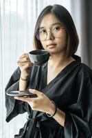 Women wearing black robes, handing coffee in the bedroom. photo