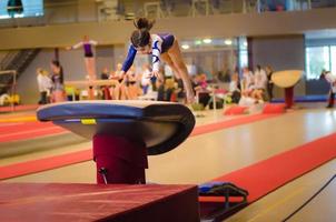 Young gymnast girl performing jump photo