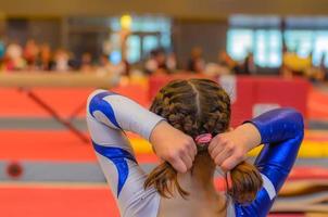 joven gimnasta arreglando el cabello antes de la aparición foto