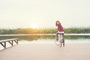 Woman feet pedal bike on the wooden bridge looking back at camera,Relaxing freedom,ready to go riding. photo