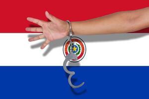 handcuffs with hand on Paraguay flag photo