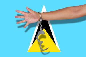 handcuffs with hand on Saint Lucia flag photo