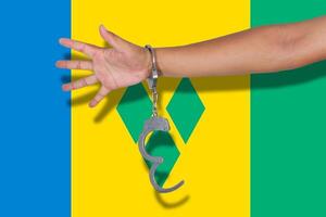 handcuffs with hand on Saint Vincent and the Grenadines flag photo