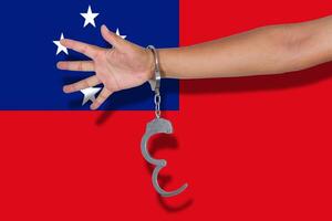 handcuffs with hand on Samoa flag photo