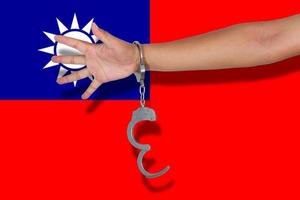 handcuffs with hand on Taiwan flag photo