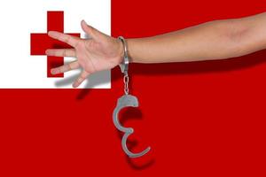 handcuffs with hand on Tonga flag photo