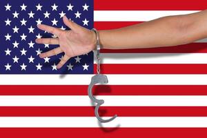 handcuffs with hand on America flag photo