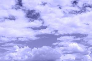 Puffy white clouds. Cloudy sky abstract background toned in very peri photo