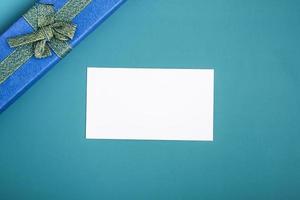 Gift box with tie and card on a turquoise background. Holiday gifts closeup with copy space photo