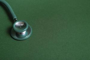 Stethoscope on green background, closeup with copy space. Medical education concept. photo