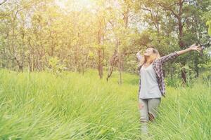 libertad hipster mujer levantando las manos en el aire, disfrutando de la naturaleza. foto