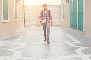 joven hipster caminando por la calle urbana con mochila en el hombro, a la aventura. foto