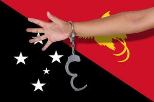 handcuffs with hand on Papau New Guinea flag photo