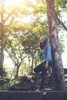 Attractive girl standing against tree, While traveling. photo