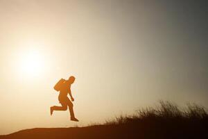 Silhouette of  young man walking to travel with sunset. photo