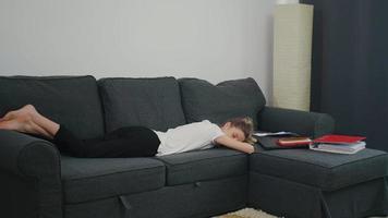 den unga kvinnan sov på soffan bredvid laptop och kontorspapper video