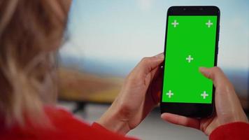 frau, die smartphone mit grünem bildschirm verwendet, wischt, scrollgesten macht. video